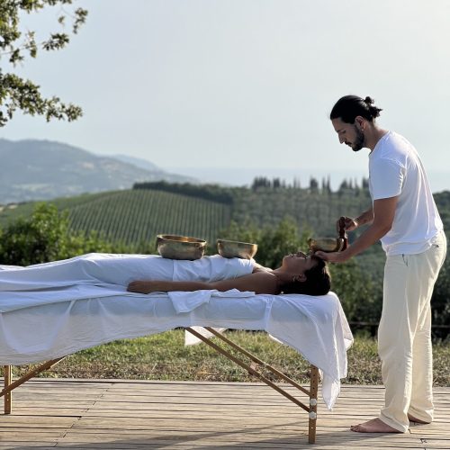 Antonio Alessandro Pinto doing sound therapy with tibetan singing bowls in a beautiful location surrounded by nature